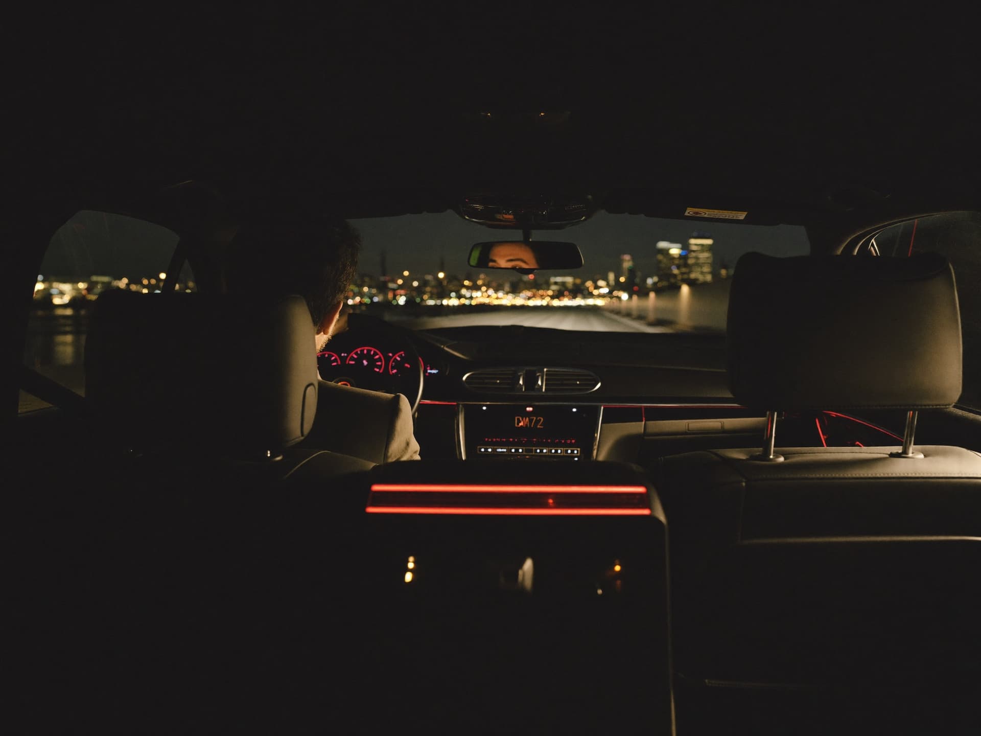 Voyageur d'affaires regardant la ligne d'horizon de Montréal depuis la banquette d'une berline avec chauffeur